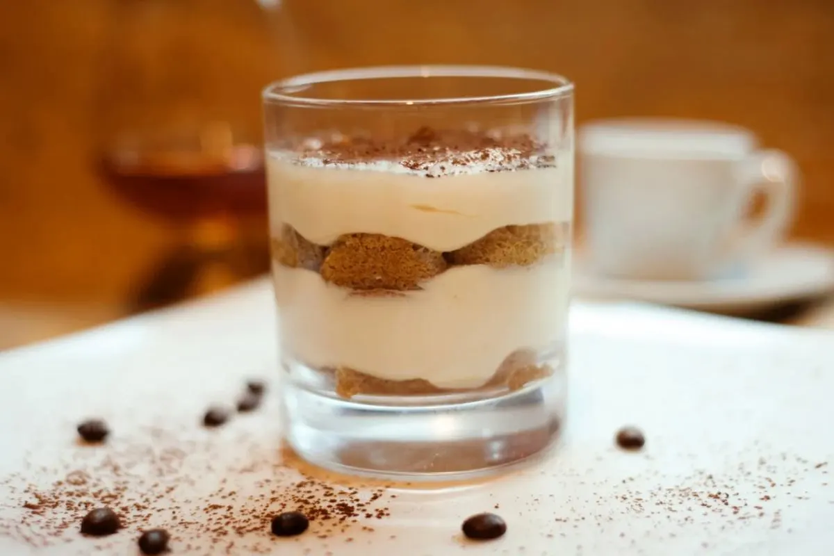 Tiramisù in un bicchiere con chicchi di caffè intorno
