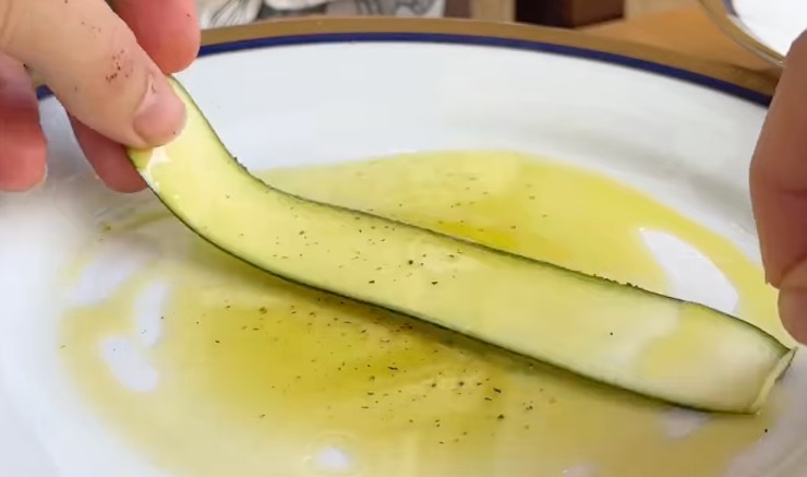 fetta di zucchina cruda su piatto con olio