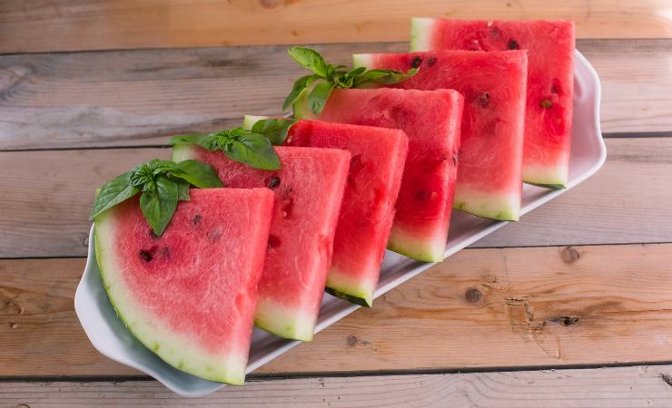 Fette di anguria su un vassoio con basilico