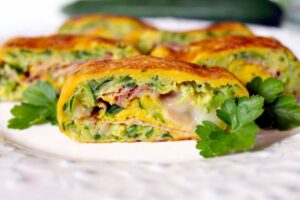Rotolo di frittata tagliato con prosciutto cotto, zucchine e formaggio