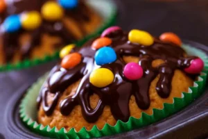Muffin in un pirottino con Smarties e glassa al cioccolato