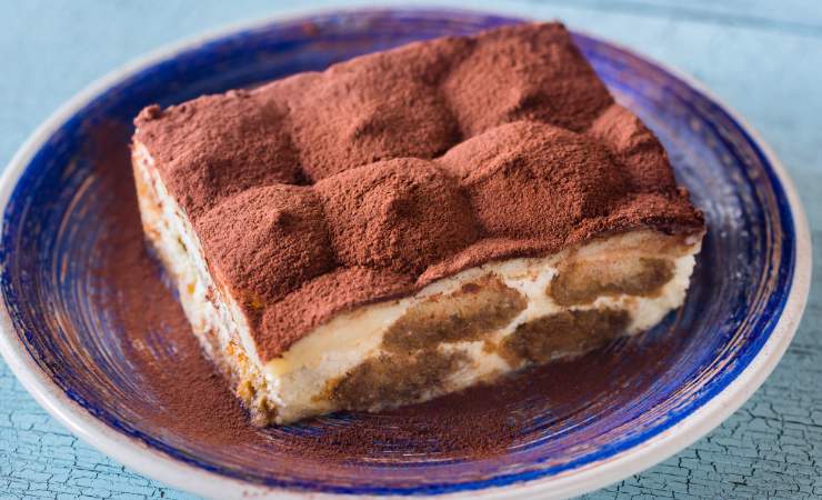 Fetta di tiramisù in un piatto blu