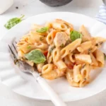 Piatto di penne con basilico, pomodorini e tonno