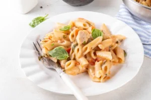Piatto di penne con basilico, pomodorini e tonno