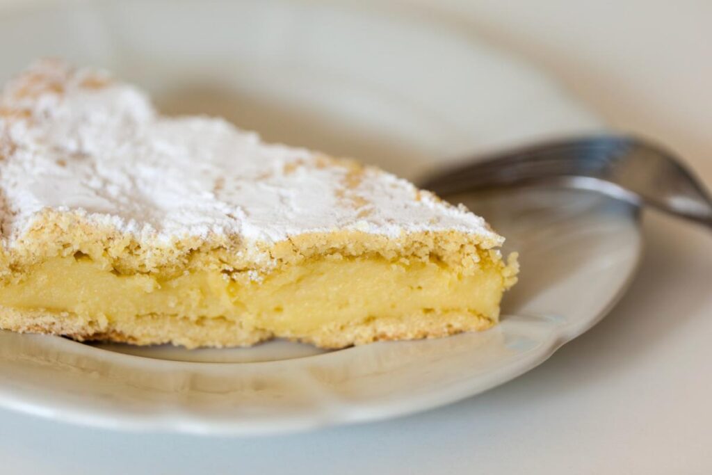 Fetta di torta con zucchero a velo e crema pasticcera