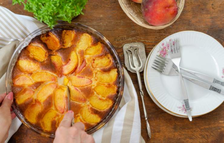 donna che taglia una fetta di torta alle pesche
