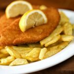 cotolette fritte con patatine in un piatto