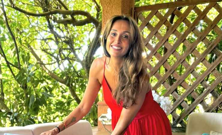 Benedetta Parodi in giardino che sorride con un vestito rosso