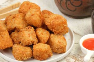 Bocconcini fritti di tofu su un piatto con salsa accanto