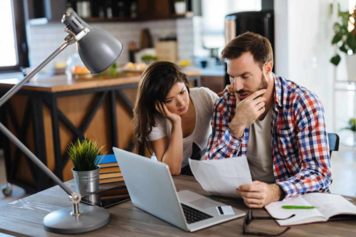 uomo e donna preoccupati mentre leggono un foglio