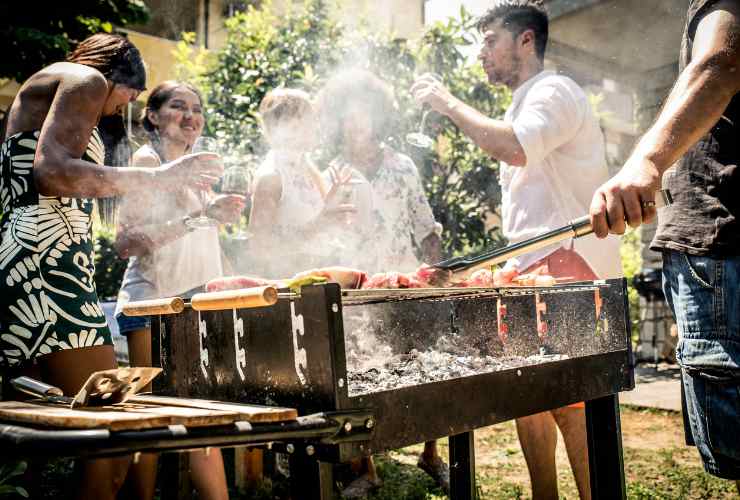 persone in giardino mentre fanno una grigliata
