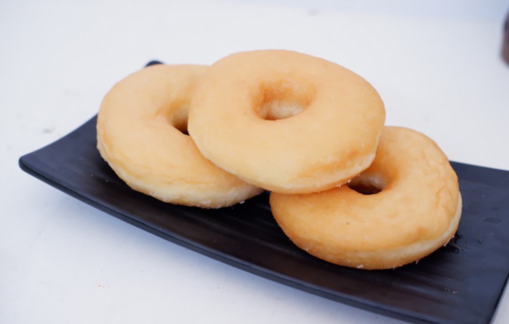 tre ciambelle dolci su un piatto nero