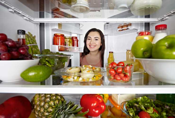 donna guarda alimenti in frigo