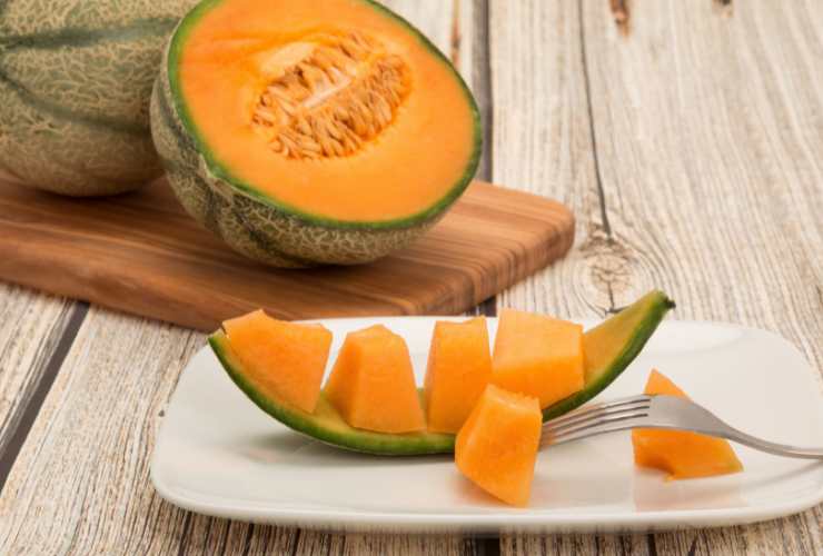 melone tagliato, una fetta nel piatto a cubetti