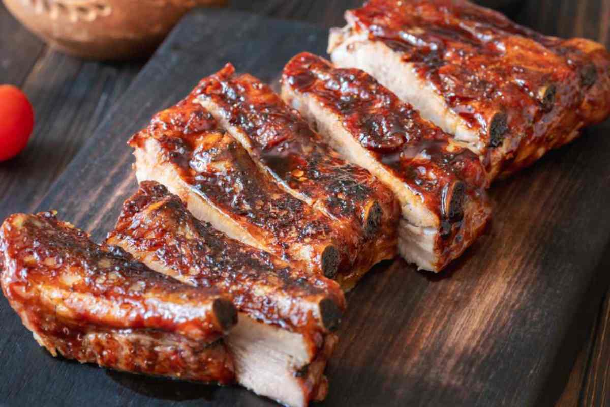 costine di maiale fumanti cotte al forno sul tagliere