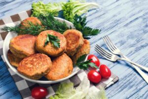 cotolette su un piatto con accanto verdure e pomodorini