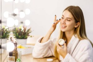 donna che applica la crema sul viso
