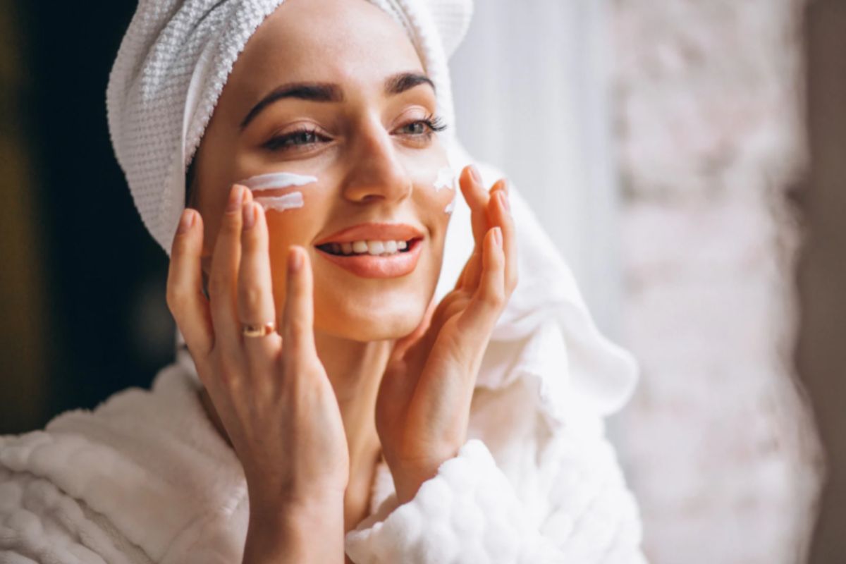 donna che si mette la crema sul viso