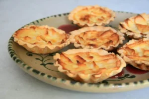 piatto in primo piano con crostatine di sfoglia e mele