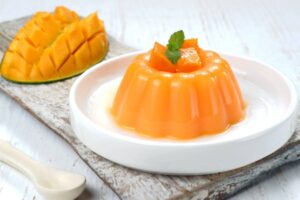 budino al mango e dietro un mango tagliato a cubetti