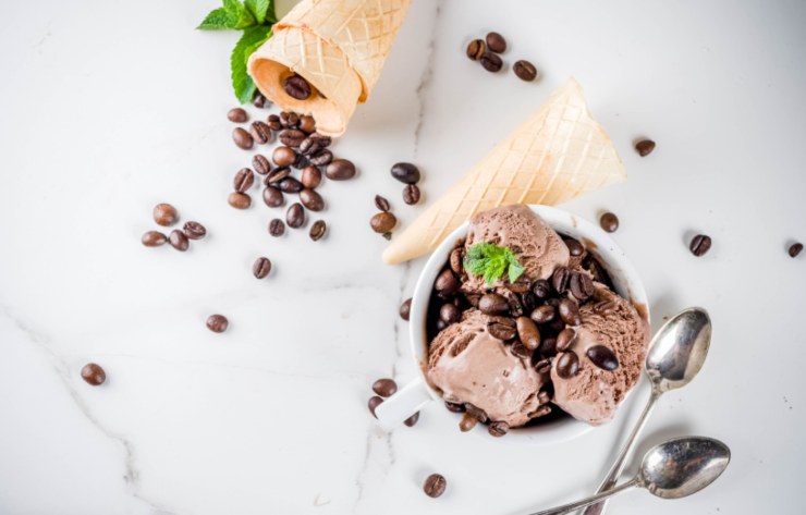 coppa di gelato al caffè con intorno delle cialde e accanto un cucchiaino