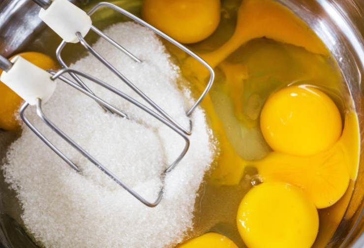 uova e zucchero in una ciotola con fruste