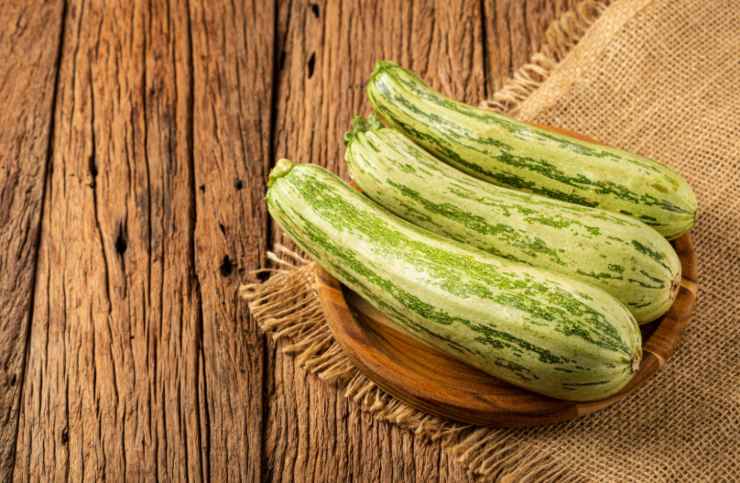 tre zucchine sopra ad un tavolo di legno