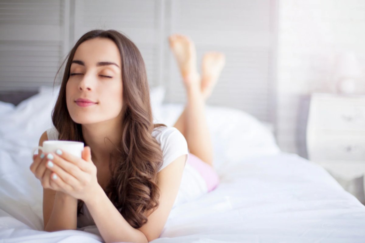 donna che beve il caffè a letto