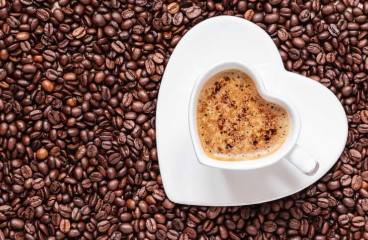 tazzina di caffè in mezzo a chicchi di caffè