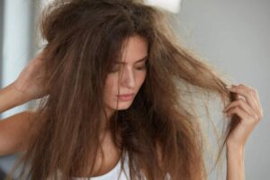donna che si tocca i capelli secchi