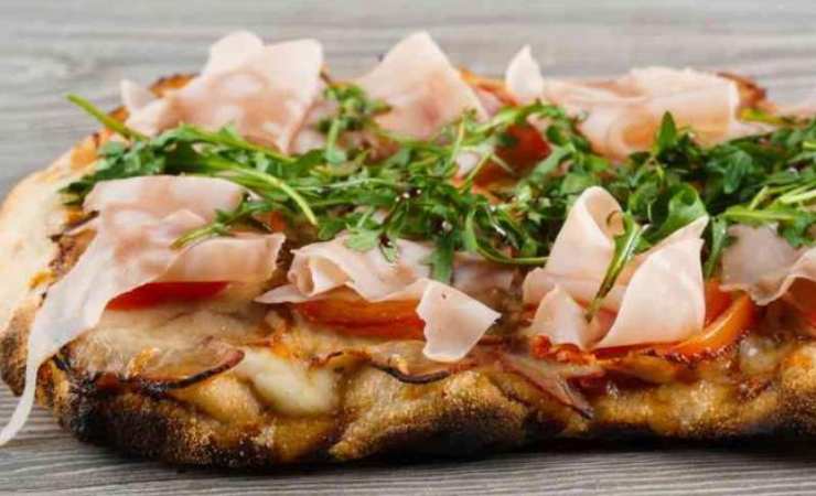 pinsa con pomodoro prosciutto e rucola