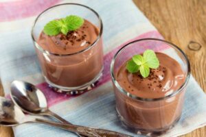 Due bicchieri di mousse al cioccolato con foglie di menta