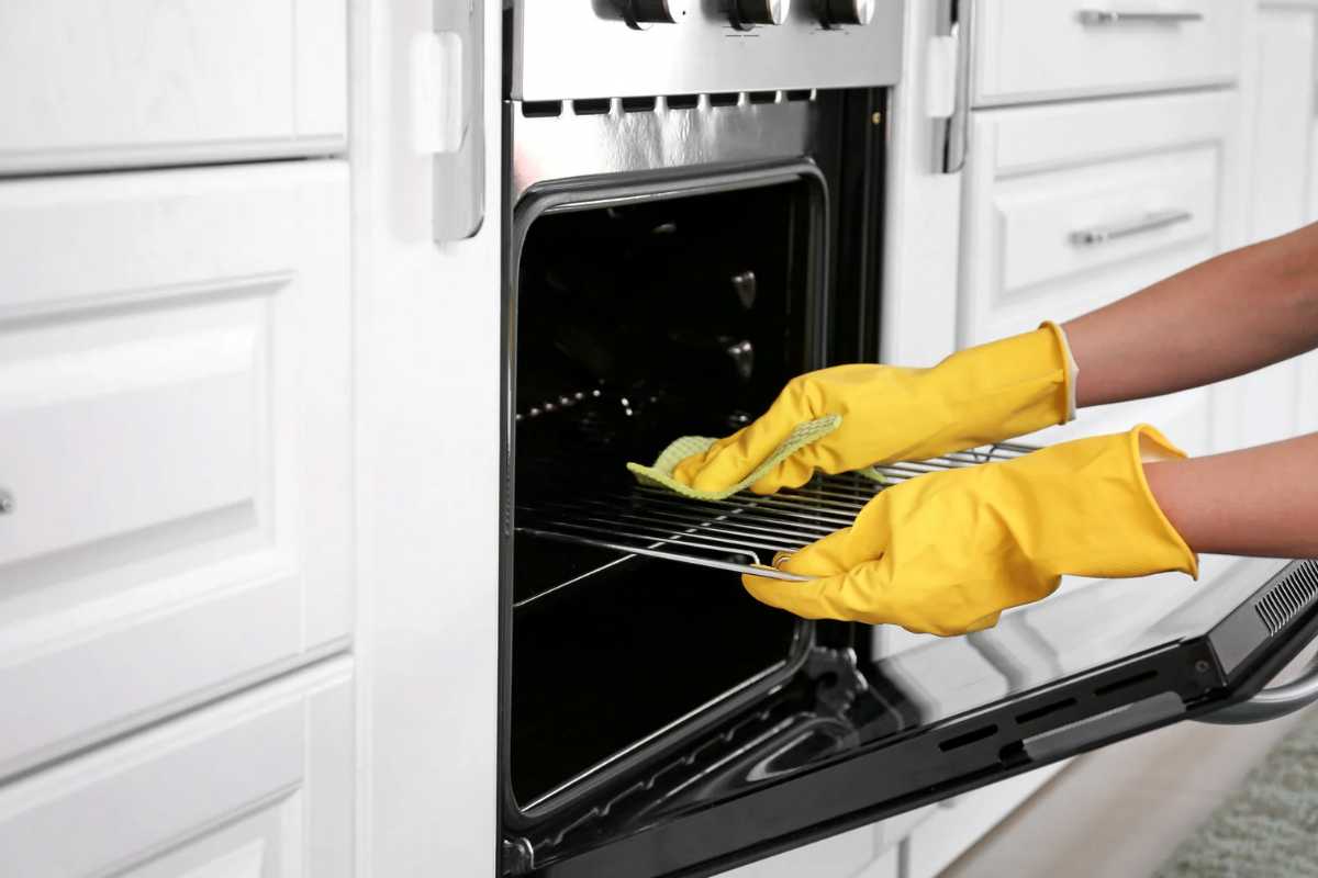 Donna che pulisce forno
