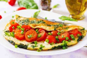 omelette con pomodorini, basilico e mozzarella nel piatto
