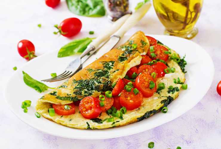 omelette con pomodorini, basilico e mozzarella nel piatto