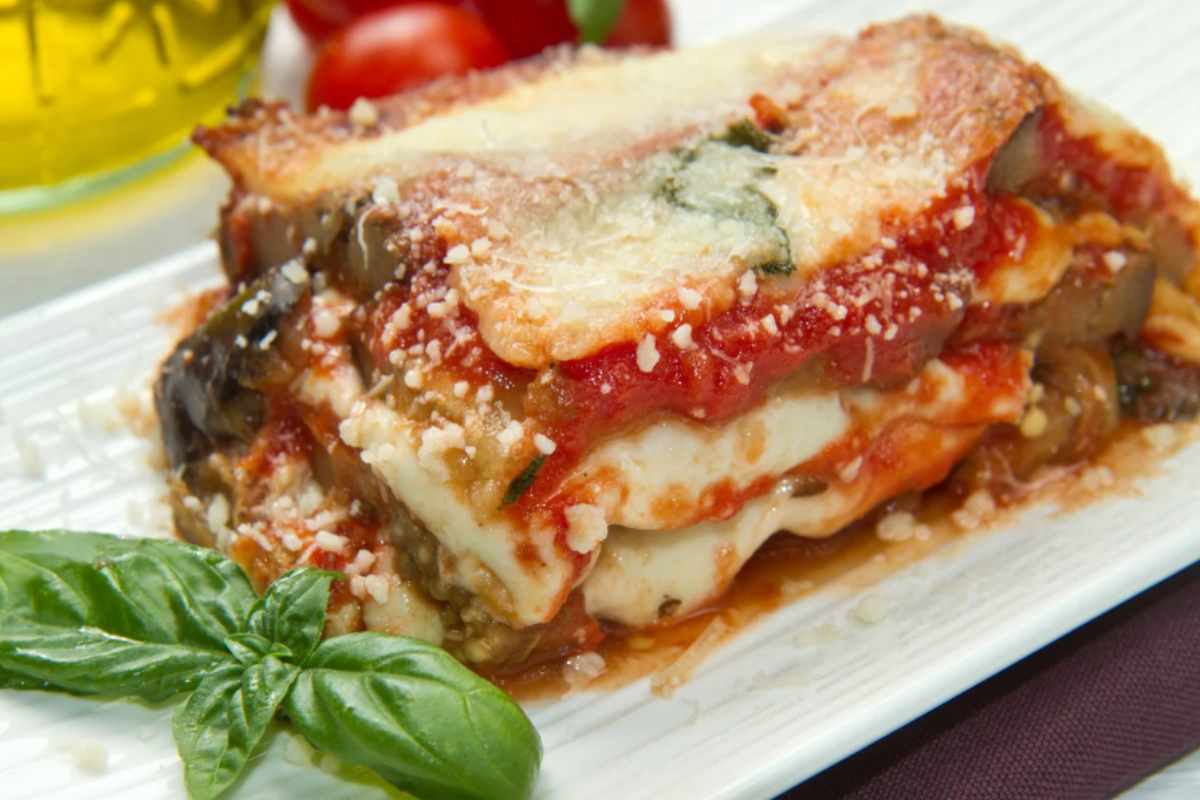 parmigiana su vassoio con pomodoro e mozzarella