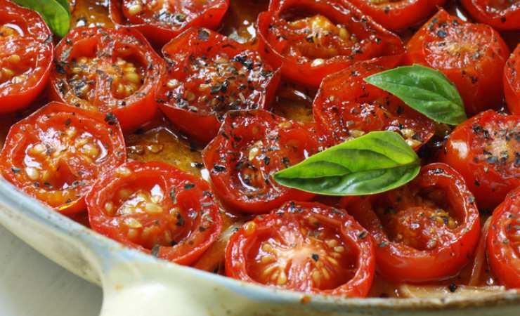 Padella con pomodori tagliati a metà e basilico