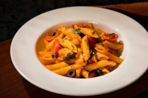 pasta con pesto di pomodori secchi e basilico e rondelle di olive