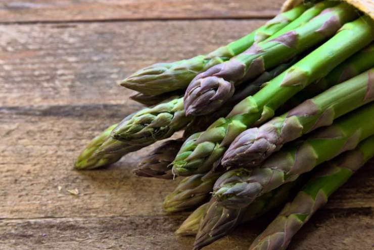 asparagi freschi su tavolo di legno