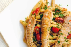 piatto di pasta con cicale e pomodorini