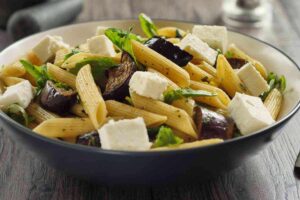 Piatto con penne, feta e melanzane