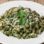 gnocchi al pesto con sopra del formaggio grattugiato
