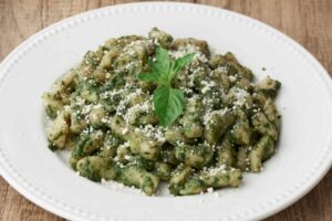 gnocchi al pesto con sopra del formaggio grattugiato