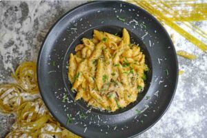 penne allo zafferano in un piatto nero