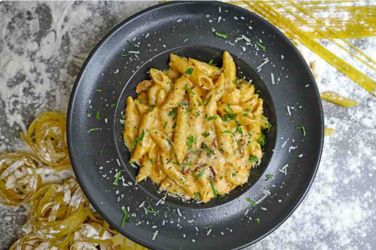 penne allo zafferano in un piatto nero