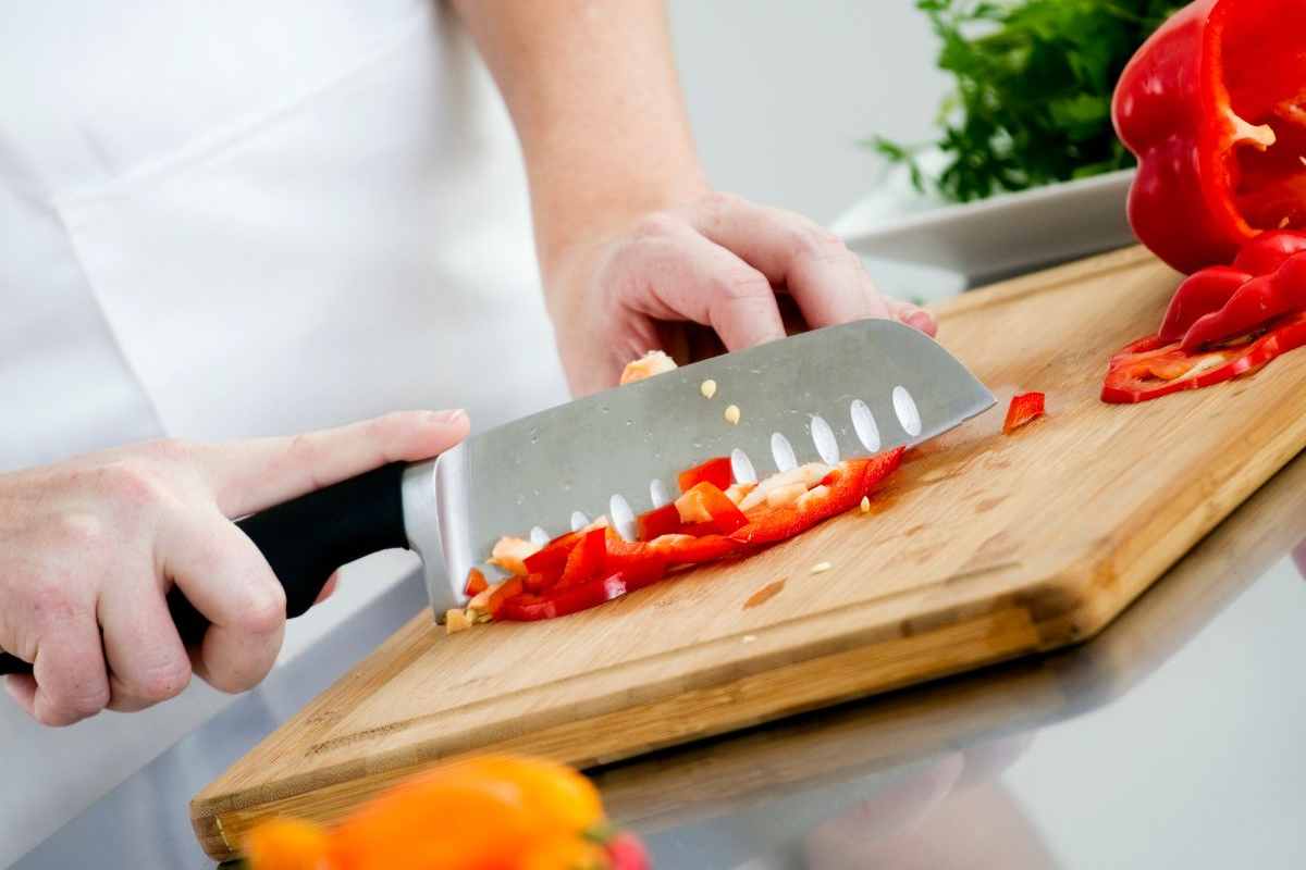 persona affetta peperoni su un tagliere