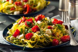 spaghetti di zucchine con pomodori e tofu a cubetti
