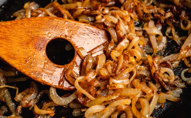 mestolo di legno con cipolle caramellate