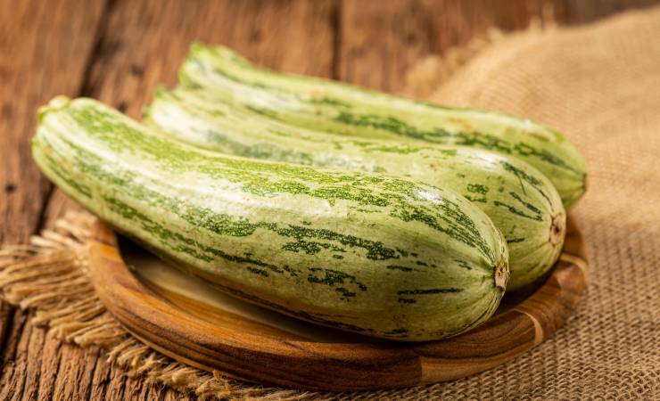 Tre zucchine su un supporto di legno