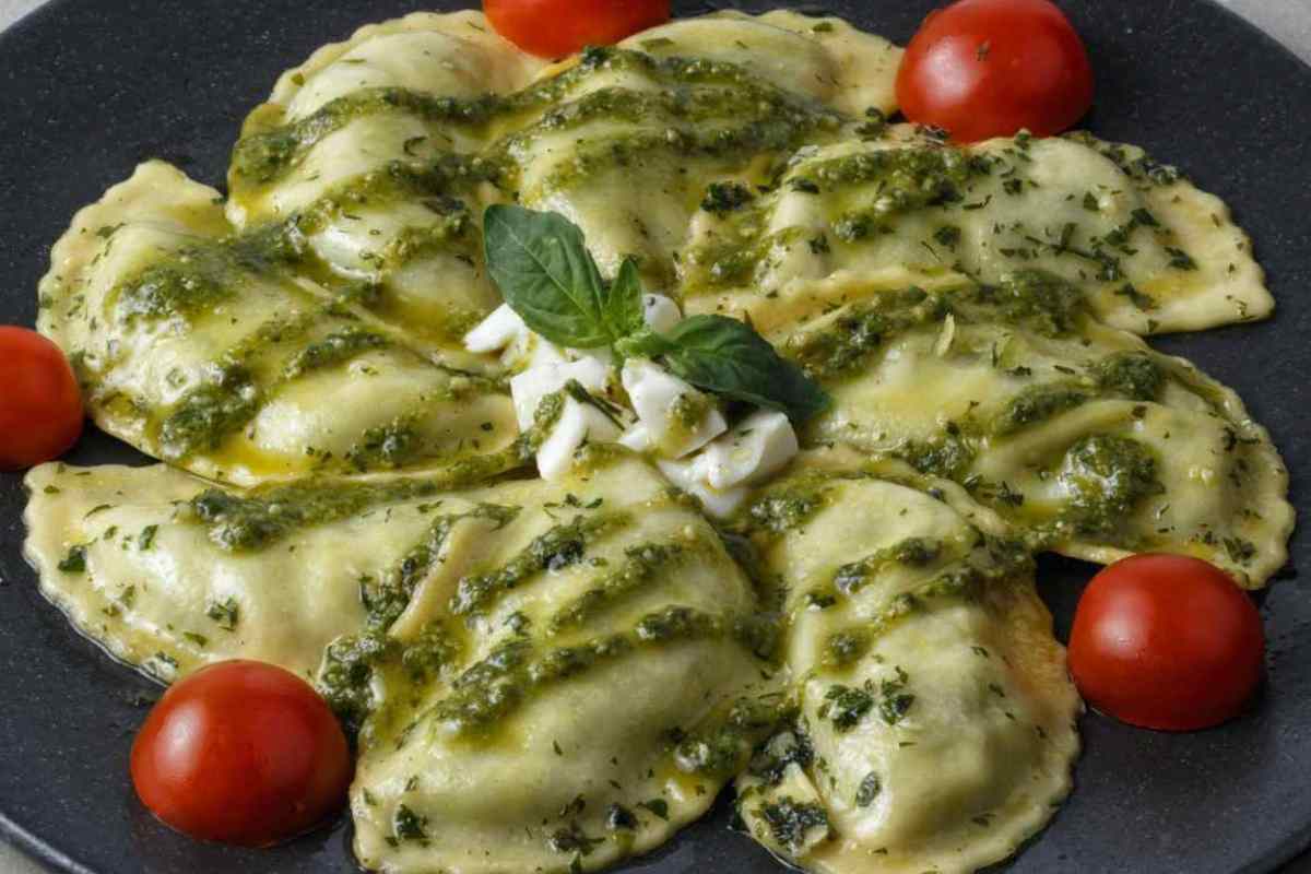 piatto con ravoli, pesto e pomodorini